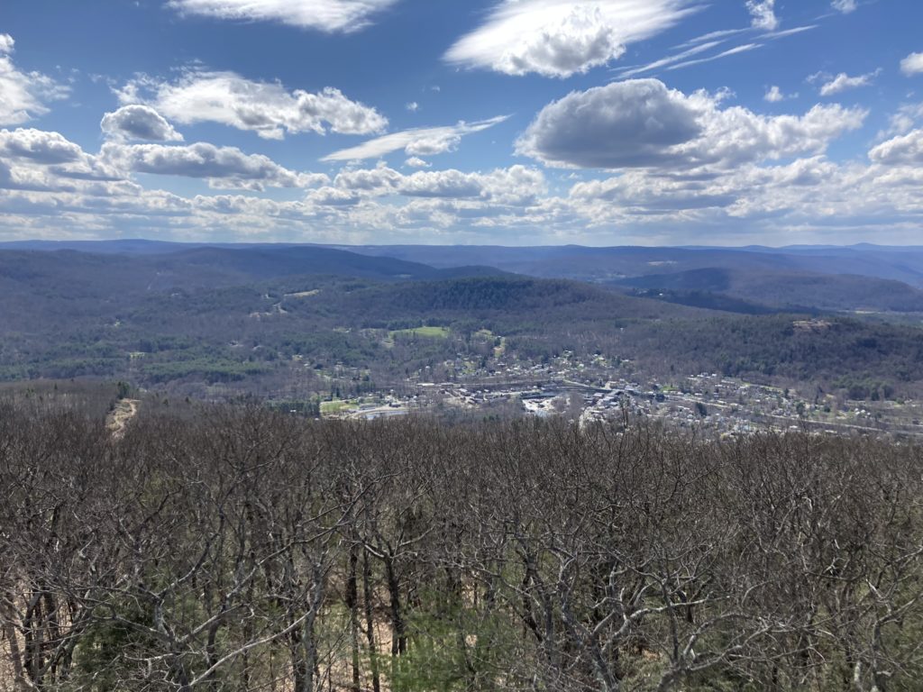 Looking down from the top of the mountain towards a small town nestled into the valley below.